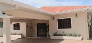 uma casa com um telhado vermelho e uma porta preta em CORONADO, LAS BRISAS em Playa Coronado