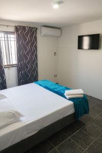 1 dormitorio con 1 cama blanca grande con sábanas azules en Access Blue Cristal en Monterrey