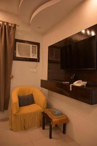 a living room with a chair and a flat screen tv at بيوتات الزير in Al Baha