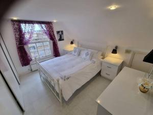 a white bedroom with a bed and a window at Beautiful apartment in the heart of Rochester in Rochester