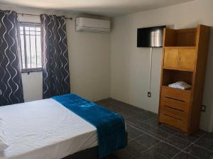 um quarto com uma cama, um armário e uma janela em Access Blue Cristal em Monterrey