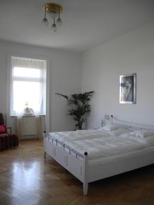 - une chambre blanche avec un lit blanc et une fenêtre dans l'établissement Jugendstil Apartment, à Vienne