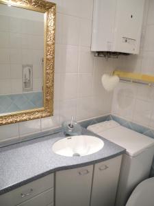 La salle de bains est pourvue d'un lavabo, d'un miroir et de toilettes. dans l'établissement Jugendstil Apartment, à Vienne