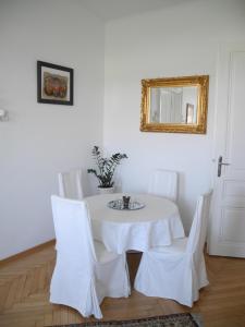 une table blanche avec des chaises blanches et un miroir dans l'établissement Jugendstil Apartment, à Vienne