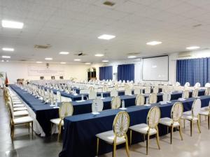 a large room with blue tables and chairs and a screen at Milpark Hotel in Cafumpe
