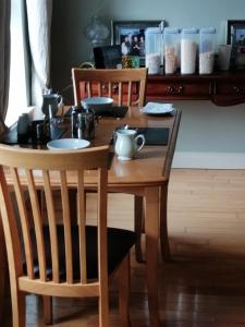 een houten tafel met twee stoelen en een tafel met borden erop bij Clonoughter Heights in Glin