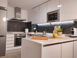 a kitchen with white cabinets and a white counter top at Las Dos Torres in Teruel