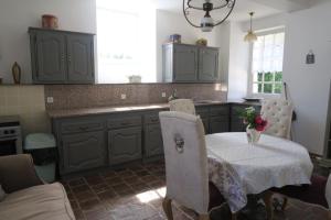 a kitchen with a table and some chairs and a table and a kitchen at Colombier du château in Vitry-la-Ville