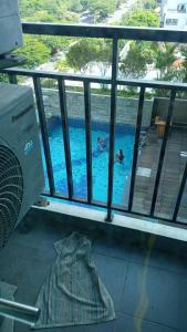 eine Person in einem Pool auf einem Balkon in der Unterkunft Aliston Papilio Apartment in Ngawinan