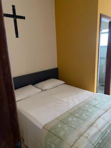 Marge Hotel في أباريسيدا: سرير في غرفة مع صليب على الحائط