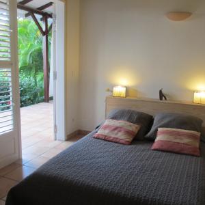 a bedroom with a bed with two pillows on it at Anse Figuier Gites de France in Terre-de-Haut