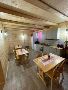 eine große Küche mit Holztischen und -stühlen in der Unterkunft Agroturystyka Wudarsówka in Sokolec
