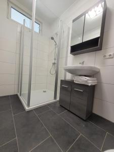 a white bathroom with a sink and a shower at Ferienwohnung Holzland in Bad Klosterlausnitz +13 photos