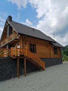 a large log cabin with a wooden deck at Agroturystyka Wudarsówka in Sokolec