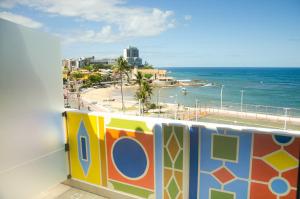 a balcony with a view of the ocean and a beach at Pousada e Hostel Chez Marianne in Salvador