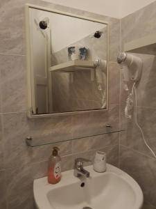 a bathroom with a white sink and a mirror at Residenza ICHNUSA in Villasimius