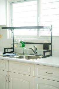 a kitchen sink with a metal shelf above it at Casa Familiar para hospedaje privado en Mérida in Mérida