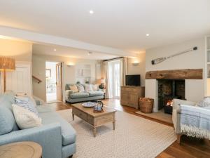 a living room with a blue couch and a fireplace at Fisherbridge Cottage in Weymouth