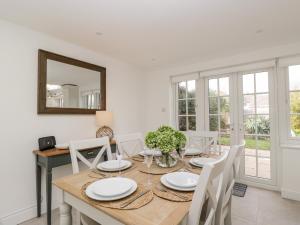 a dining room with a table and chairs and a mirror at Fisherbridge Cottage in Weymouth