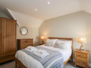 a bedroom with a bed with towels on it at Fisherbridge Cottage in Weymouth