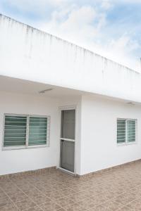 a white building with two windows and a roof at Casa Familiar para hospedaje privado en Mérida in Mérida