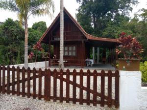 a wooden fence in front of a house at Chalé Da Bia in Cananéia