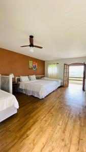 a large bedroom with two beds and a ceiling fan at Paraty Hotel Fazenda & Spa in Ibiúna