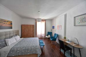 a bedroom with a bed and a desk with chairs at Matriz Guest House in Portel