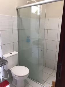 W łazience znajduje się toaleta i przeszklony prysznic. w obiekcie Apartamento em Taiba-CE com vista para o mar w mieście Taíba