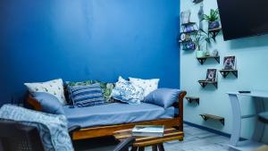 een blauwe woonkamer met een blauwe bank met kussens bij 1-bedroom apartment with secure basement parking in Stellenbosch
