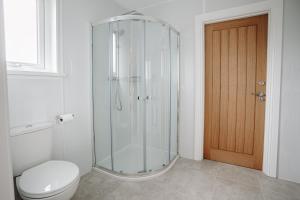 a bathroom with a glass shower and a toilet at Mountain View Lodge in Newcastle