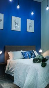 a blue bedroom with a bed with a blue wall at 1-bedroom apartment with secure basement parking in Stellenbosch