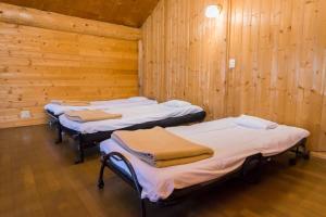 3 Betten in einem Zimmer mit Holzwänden in der Unterkunft Haskap - Vacation STAY 40804v in Tōya