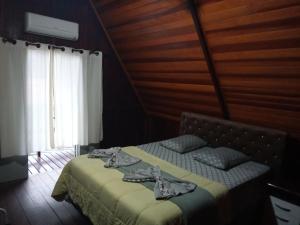 een slaapkamer met een bed in een houten kamer bij Chalé Da Bia in Cananéia