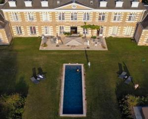 einen Luftblick auf ein großes Haus mit einem Pool in der Unterkunft Château de la Giraudière in Villeny