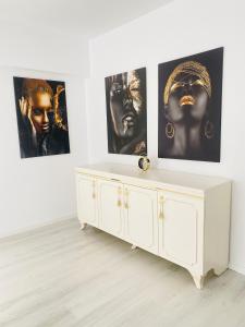 坎普朗莫道尼斯Luxury Queen的墙上有三张照片的房间的白色橱柜