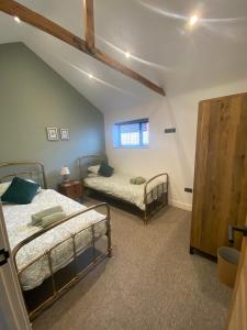 a bedroom with two bunk beds and a window at The Potting Shed in Bredon