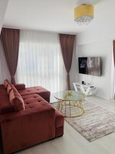 uma sala de estar com um sofá vermelho e uma mesa de vidro em Luxury Queen em Câmpulung Moldovenesc