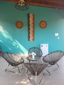 3 sedie e un tavolo di fronte a una parete blu di Pousada Tauari ad Alter do Chão