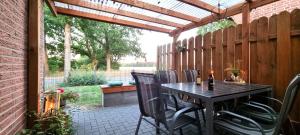 eine Terrasse mit einem Tisch und Stühlen unter einer Pergola in der Unterkunft Ferienwohnung Wipperau I in Uelzen