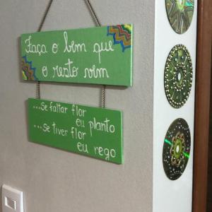 a green sign is hanging on a wall at Recanto dos Guimarães in Palhoça