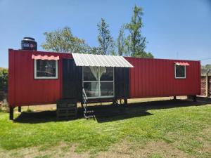 a red and black tiny house in a yard at Casa Conteiner in Salta