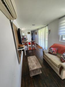 ein Wohnzimmer mit einem Sofa und einem Tisch in der Unterkunft Casa Conteiner in Salta