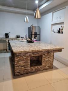 a kitchen with a brick island in the middle at Pura vida apartament 5 min near aiport NO PARKING SITE in Alajuela
