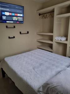 1 dormitorio con 1 cama y TV en la pared en Pura vida apartament 5 min near aiport NO PARKING SITE en Alajuela City