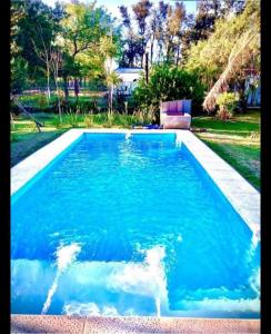 einen Pool mit blauem Wasser im Hof in der Unterkunft El Carmelo in Santiago del Estero