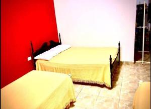 um quarto com 2 camas e uma parede vermelha em El Carmelo em Santiago del Estero
