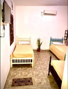 Zimmer mit 2 Betten und einem TV an der Wand in der Unterkunft El Carmelo in Santiago del Estero
