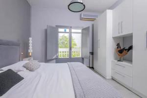 een witte slaapkamer met een groot bed en een raam bij Dolce Vita in La Marsa