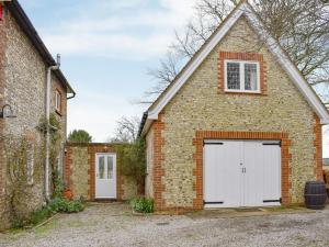 a brick house with a white garage at Goodwood Coach House in Westhampnett